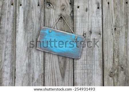 Blank ice teal blue wood sign hanging on rustic wooden background
