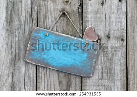 Blank ice teal blue antique wood sign with heart hanging on rustic wooden background