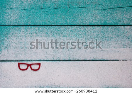 Blank antique teal blue sign with fading sand texture and red sunglasses