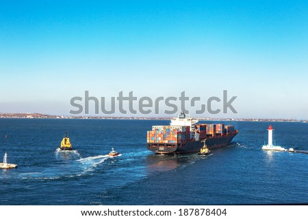 ODESSA, UKRAINE - NOVEMBER 24: Marine cargo ship loaded with shipping containers Ukrainian industrial goods coming out of harbor seaport. Vorontsov Lighthouse , November 24, 2011 Odessa, Ukraine