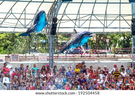 ODESSA, UKRAINE - JUNE 10, 2013: Dolphins on creative entertaining show at  dolphinarium with  full house of visitors show amazing tricks. Spectators happily delighted June 10, 2013 in Odessa, Ukraine