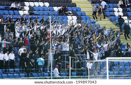 ODESSA, UKRAINE - July 10, 2013: emotional football fans support the team at the stadium during a game of football club Chernomorets, July 10, 2013, Odessa, Ukraine