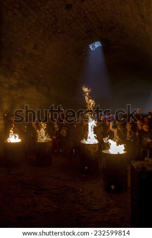 Odessa, Ukraine - November 22: Local rock band plays concert in underground catacombs dungeon destroyed building. A crowd of happy people, fans around campfire enjoy, November 22, 2014 Odessa, Ukraine