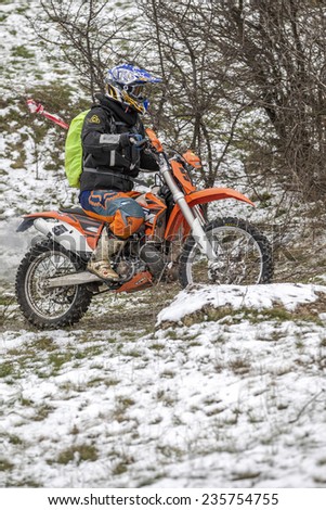 Odessa, Ukraine - December 6, 2014: Off-road motorcyclist on motocross off-road route passes in winter mountains, December 6, 2014 in Odessa, Ukraine.