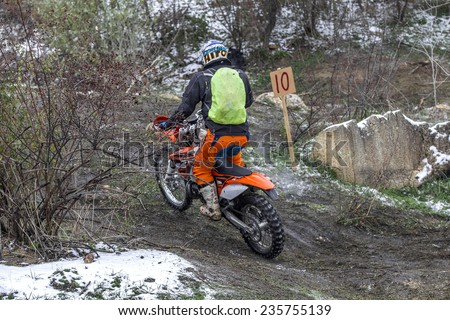 Odessa, Ukraine - December 6, 2014: Off-road motorcyclist on motocross off-road route passes in winter mountains, December 6, 2014 in Odessa, Ukraine.
