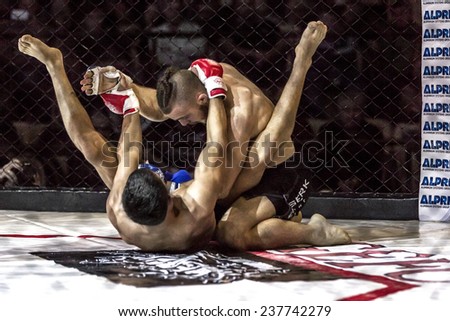 Odessa, Ukraine - December 13: Athletics MMA mixed martial arts fighters compete in the cell, causing punches and kicks. Dramatic moment of battle, December 13, 2014 in Odessa, Ukraine
