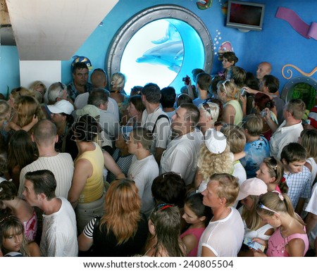 ODESSA, UKRAINE - 10 August 2007: joyful spectators stand in line to represent the Dolphinarium, against the background of the underwater portholes with dolphins, August 10, 2007 in Odessa, Ukraine.