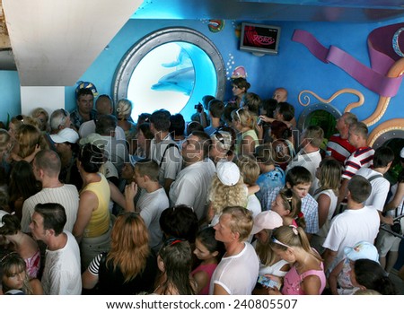 ODESSA, UKRAINE - 10 August 2007: joyful spectators stand in line to represent the Dolphinarium, against the background of the underwater portholes with dolphins, August 10, 2007 in Odessa, Ukraine.