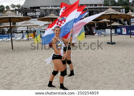 Odessa, Ukraine - September 4, 2010: Bright dynamic performance of the women\'s support group sports team on sandy shores of Black Sea. Cheerleaders in Aktion. Bright beautiful young girl in sportswear