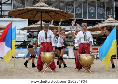Odessa, Ukraine - September 4, 2010: Bright dynamic performance of the women\'s support group sports team on sandy shores of Black Sea. Cheerleaders in Aktion. Bright beautiful young girl in sportswear