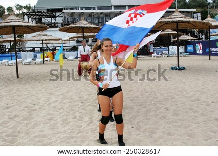 Odessa, Ukraine - September 4, 2010: Bright dynamic performance of women\'s support group sports team on sandy shores of the Black Sea. Cheerleaders in Aktion. Bright beautiful young girl in sportswear