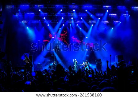 Odessa, Ukraine - June 28, 2014: A large crowd of people having fun at stadium, at a concert of Ukrainian group Okean Elzy during the creative light and music show. Cheerful bright show at club party