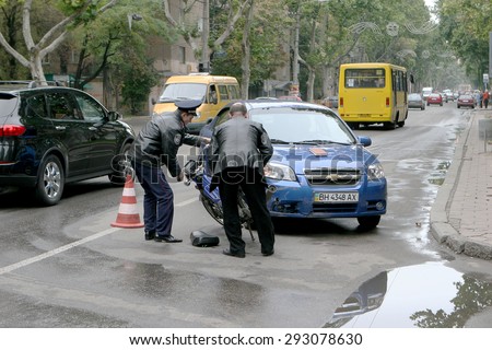 Odessa, Ukraine - October 4, 2008: Light accident between a car and a motorcycle. Bike crashed into a car. He lost control on the wet asphalt. Powered Police