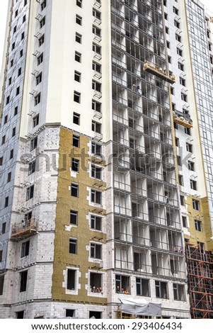 ODESSA, UKRAINE - JUNE 18 2014: Construction of high-rise residential building works on the outer facade of building insulation, insulation. Modern technology in the construction of thermal insulation