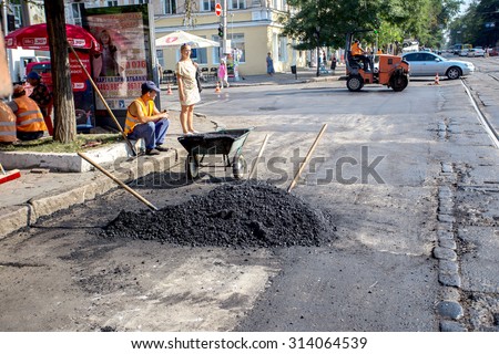 Odessa, Ukraine, August 16, 2015 - repair of asphalt road in the city center. hole in the asphalt in the parking of the carriageway. Job asphalt surfacing machinery