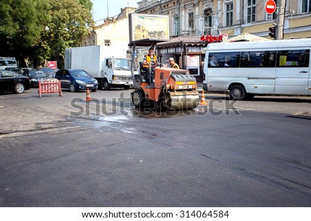 Odessa, Ukraine, August 16, 2015 - repair of asphalt road in the city center. hole in the asphalt in the parking of the carriageway. Job asphalt surfacing machinery