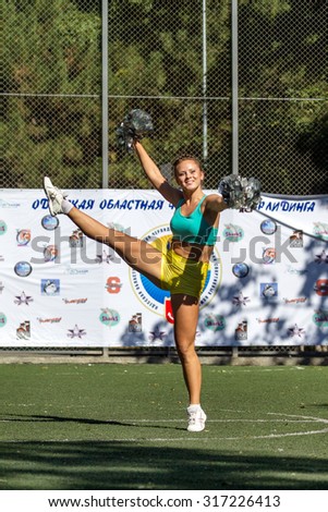 Odessa, Ukraine - September 2, 2015: Bright dynamic characteristics of a support group of women\'s sports team. Performance Support Group. Bright beautiful young girl in sports dance form on playground