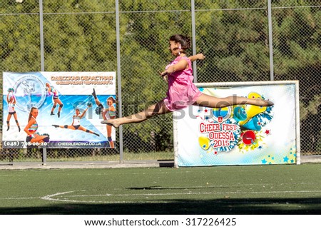 Odessa, Ukraine - September 2, 2015: Bright dynamic characteristics of a support group of women's sports team. Performance Support Group. Bright beautiful young girl in sports dance form on playground
