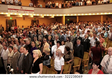 Odessa, Ukraine - June 25, 2010: Zritelnny Hall Concert Hall. Spectators before the solemn meeting and a concert. Spectators stot during the anthem of the state. The audience in the hall.