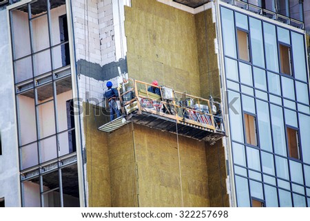 ODESSA, Ukraine - SEPTEMBER 17, 2015: facade thermal insulation works with stopping and fillers during the construction of high-rise apartment building
