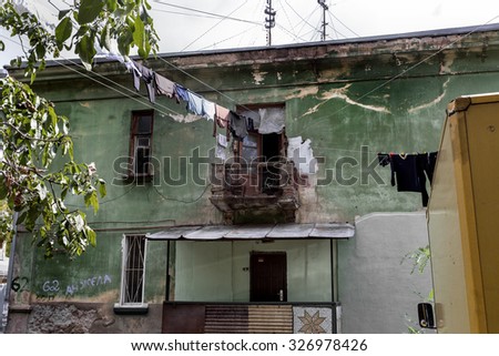 Odessa, Ukraine - October 12, 2015: Destruction, emergency balcony of a house. Living in poor neighborhood. Residents of home washed and dried laundry on a clothesline in  crumbling house for the poor