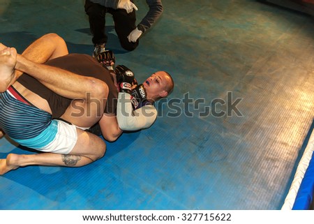 Odessa, Ukraine - October 14, 2015: Regional fights in the ring. Athletics MMA mixed martial arts fighters to compete, resulting in the throws and punches and kicks. The dramatic moment of the battle