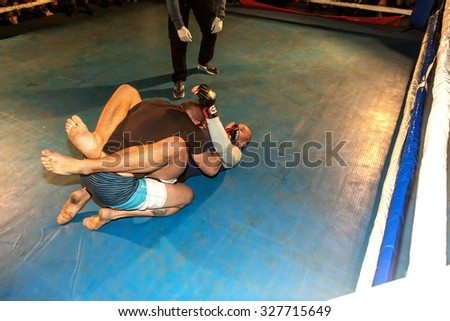 Odessa, Ukraine - October 14, 2015: Regional fights in the ring. Athletics MMA mixed martial arts fighters to compete, resulting in the throws and punches and kicks. The dramatic moment of the battle
