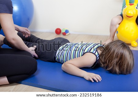 a female physiotherapist makes physiotherapy with young children
