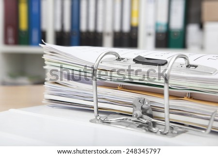 Desk in an office with a full file folder