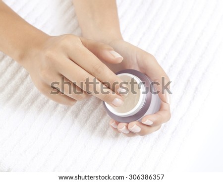 Woman\'s hands holding a nourishing cream for face care