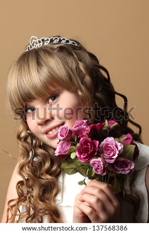 A curly hair girl with bouquet flowers and a diadem 
