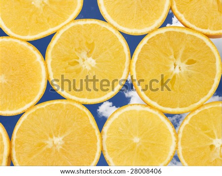 Fresh orange slices, laid out to form a pattern. A sky background has been added to add to the freshness appeal.