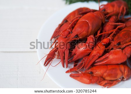 red boiled crawfish on white on a plate on a wooden board