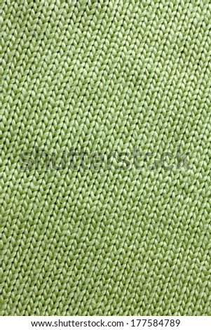 a background of sage green colored knit fabric is braided in lines