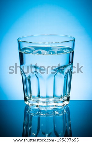 Glass of water isolated on blue background.