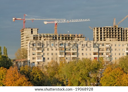 Old apartment house against building and construction crane