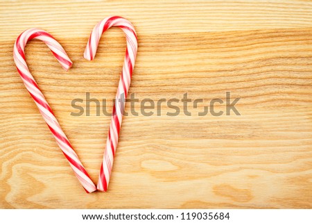 Heart made from candy canes on wood texture