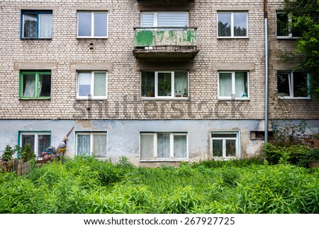 Wall of an old apartment building and abandoned garden