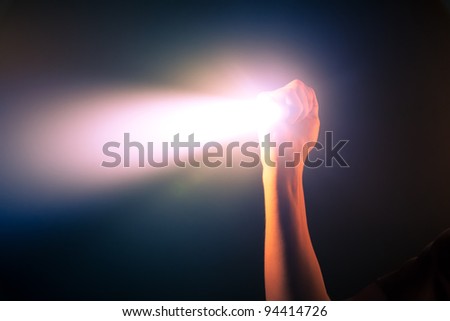 hand holding glowing pocket torch light