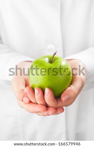 green apple in hands, white background