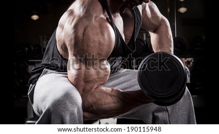Fit men training his bicep at the gym