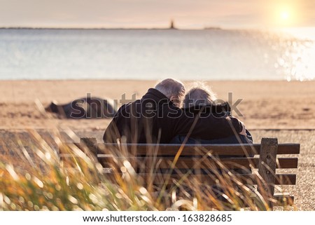 elderly couple enjoying the sunset at the beach