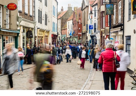WHITBY, ENGLAND - APRIL 18: People shopping on Church Street, in Whitby, North Yorkshire, England. On 18th April 2015.