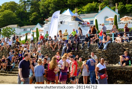 PORTMEIRION, NORTH WALES - SEPTEMBER 6: Groups of young people & families sitting on the beach wall, during Festival No.6. In Portmeirion, North Wales, United Kingdom. On 6th September 2014.