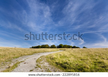 Wispy clouds over a Gravel track leading to Badbury Rings Iron age fort