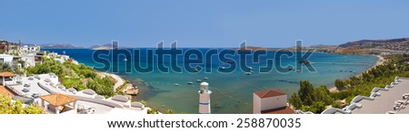 Clear blue waters and beautiful flowers can be seen past the Lighthouse at Ortakent in Turkey
