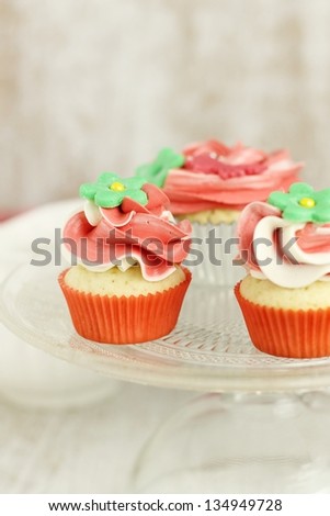 Red and white vanilla cupcakes and mini cupcakes on a cake stand
