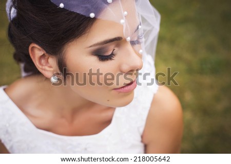 Beautiful bride preparing to get married in white dress and veil in the park alone. outdoors. copy space