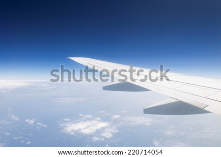 Wing of the plane in cloudless blue sky  background in the middle of a day. copy space. horizon.