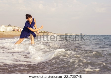 woman throwing rocks on a  sand seashore near sea looking on the water, relaxing on a vacation trip. copy space